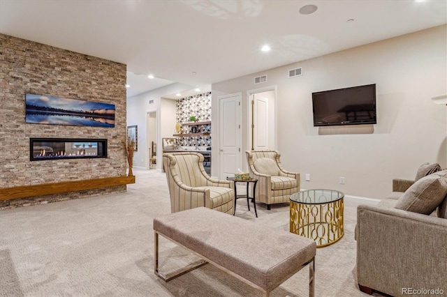 living room with a stone fireplace and light colored carpet