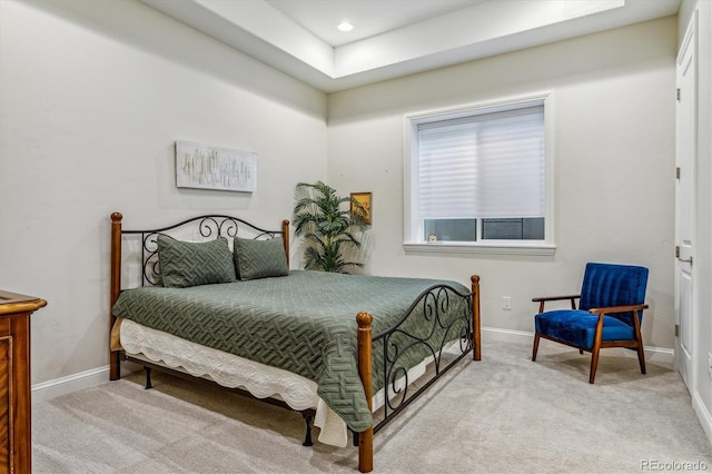 carpeted bedroom featuring a tray ceiling