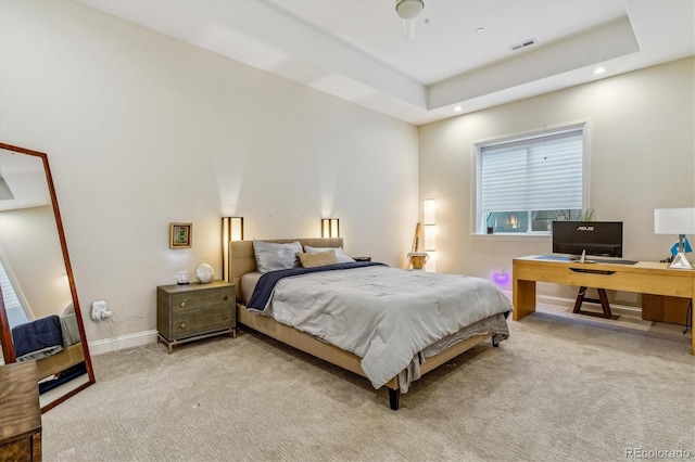 carpeted bedroom featuring a tray ceiling