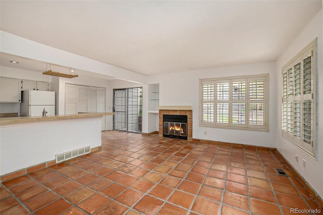 unfurnished living room with tile flooring and a fireplace