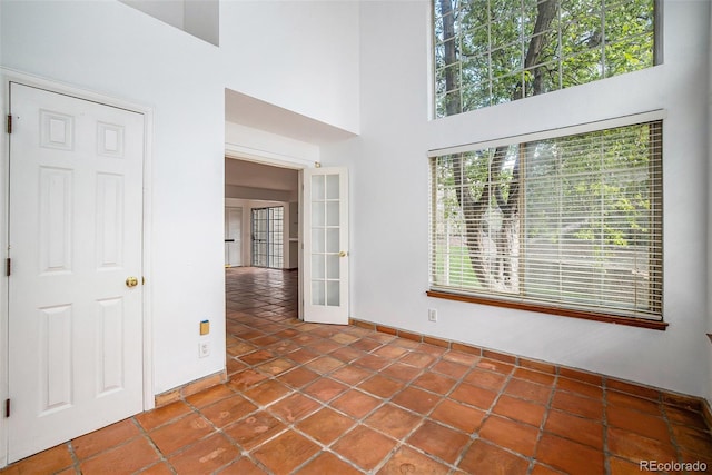 tiled spare room with french doors and a high ceiling