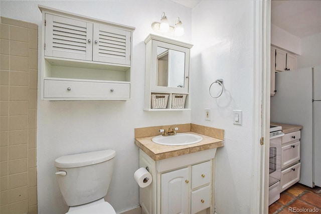 bathroom with toilet, tile floors, and vanity