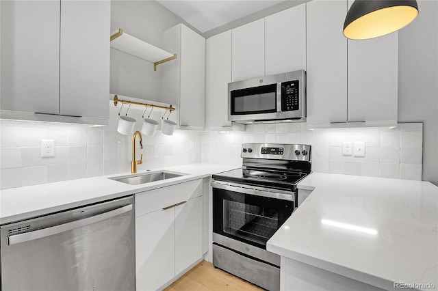 kitchen with tasteful backsplash, a sink, appliances with stainless steel finishes, modern cabinets, and open shelves