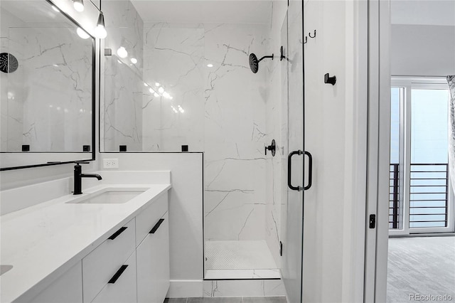 bathroom featuring a marble finish shower and vanity