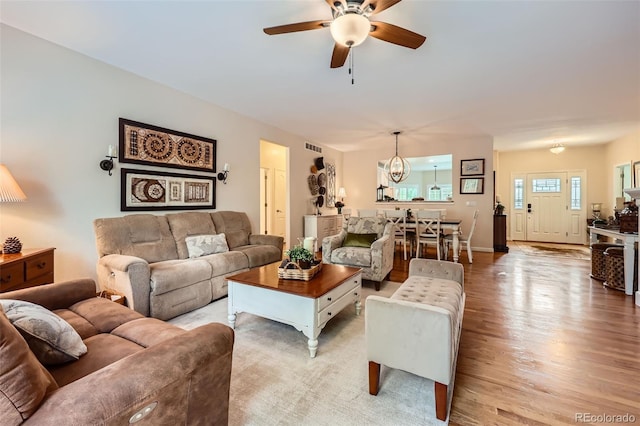21107 Hawthorne Ln, Parker, CO 80138 - living room featuring a chandelier, a ceiling fan, and light wood-type flooring