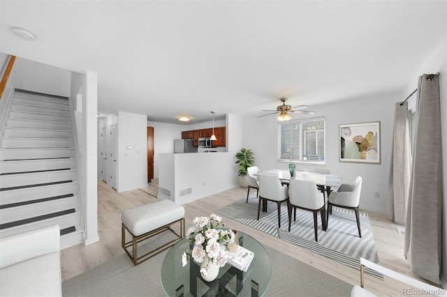 living room featuring light wood-type flooring and ceiling fan