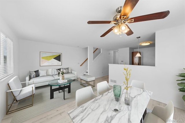 dining space with ceiling fan and light hardwood / wood-style floors