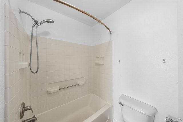 bathroom featuring toilet and tiled shower / bath