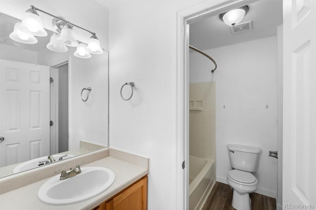 full bathroom featuring  shower combination, vanity, hardwood / wood-style floors, and toilet