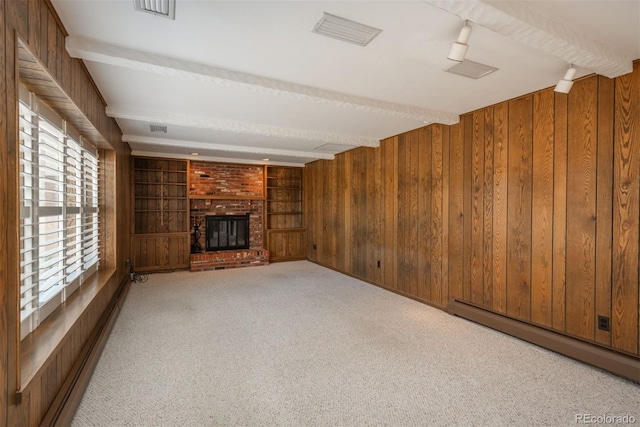 unfurnished living room with wooden walls, beamed ceiling, carpet flooring, a fireplace, and a baseboard radiator