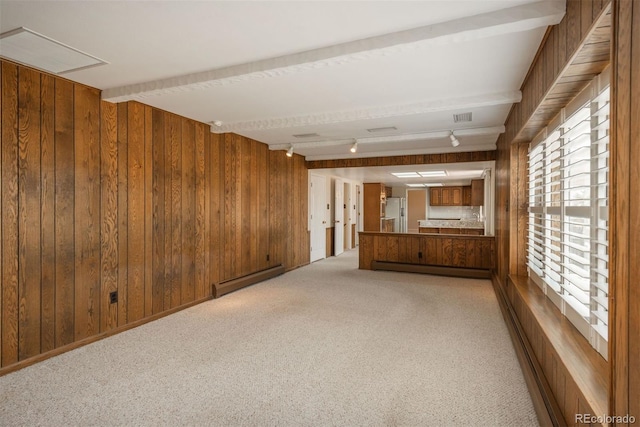 interior space with visible vents, wood walls, baseboard heating, and light carpet