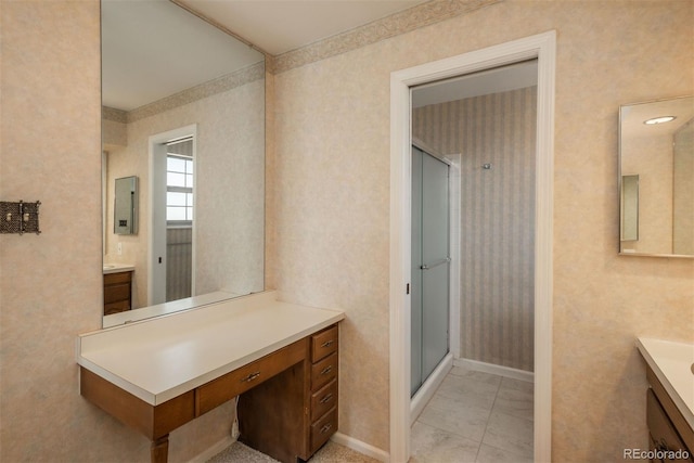 bathroom featuring wallpapered walls, a shower stall, vanity, and baseboards