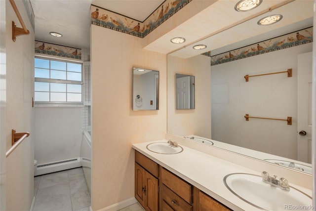 bathroom featuring a baseboard heating unit, double vanity, a bathing tub, and a sink