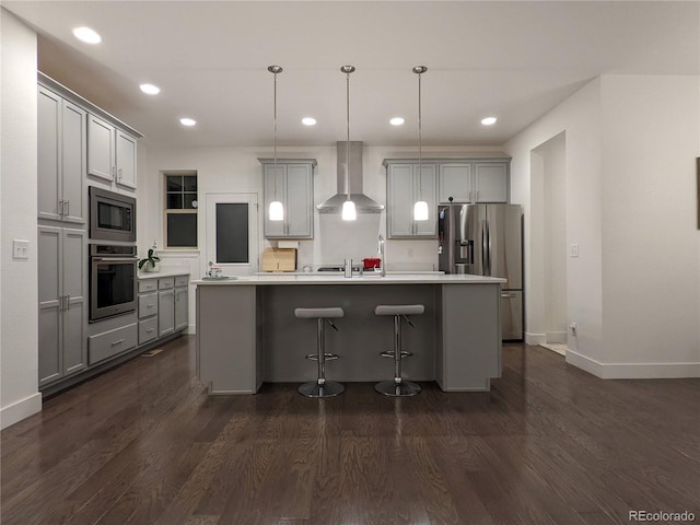 13788 Umatilla Ln, Broomfield, CO 80023 - kitchen featuring wall chimney range hood, appliances with stainless steel finishes, gray cabinets, recessed lighting, and a center island with sink