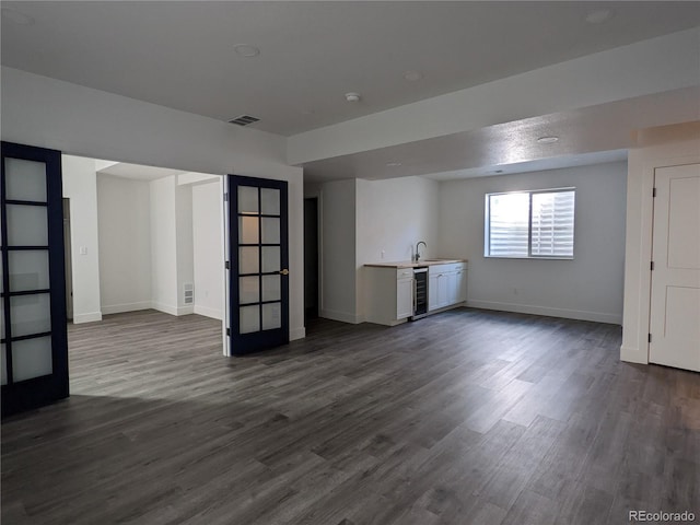 13788 Umatilla Ln, Broomfield, CO 80023 - unfurnished living room featuring beverage cooler, wet bar, and dark wood-type flooring