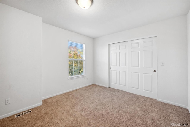 unfurnished bedroom with carpet and a closet