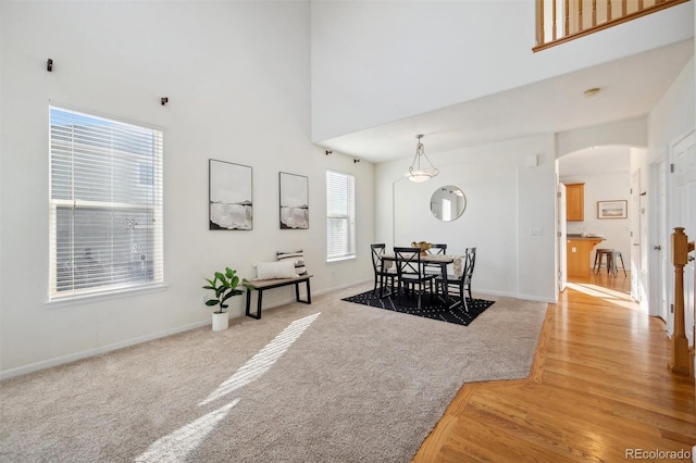 dining room with a high ceiling and light wood-type flooring