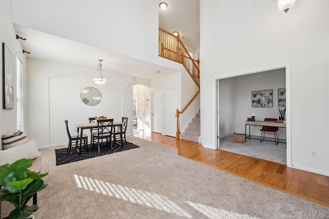 dining area featuring light hardwood / wood-style flooring and a high ceiling