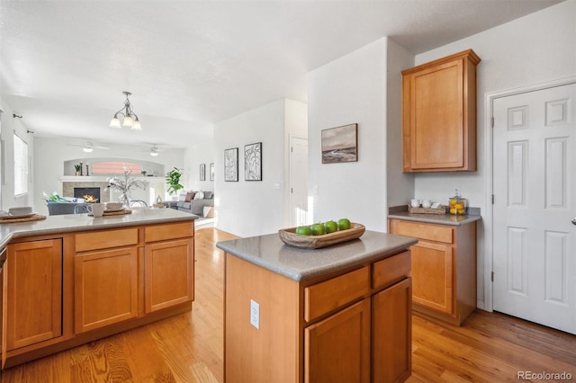 kitchen with an inviting chandelier, a center island, pendant lighting, and light wood-type flooring