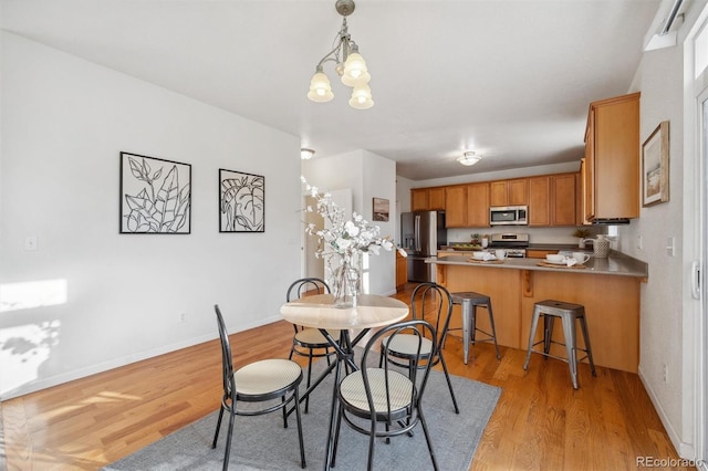 dining space featuring an inviting chandelier and light hardwood / wood-style flooring