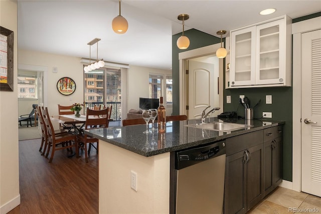 kitchen featuring dark stone counters, hardwood / wood-style flooring, dishwasher, white cabinetry, and hanging light fixtures