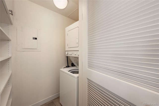 laundry area with stacked washer and dryer and electric panel