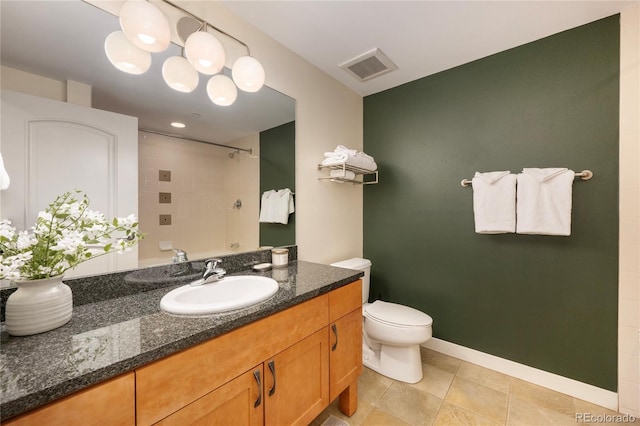 bathroom with tile patterned flooring, vanity, toilet, and a tile shower