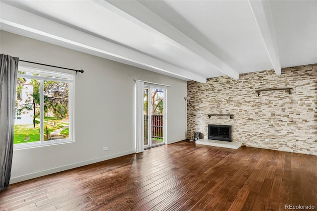 9995 E Harvard Ave Unit 290, Denver, CO 80231 - unfurnished living room with beamed ceiling, wood-type flooring, healthy amount of natural light, and a fireplace