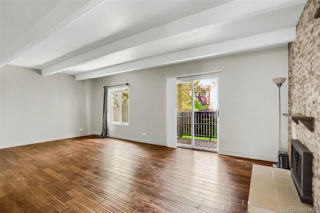 9995 E Harvard Ave Unit 290, Denver, CO 80231 - unfurnished living room with beamed ceiling, hardwood / wood-style flooring, a fireplace, and baseboards