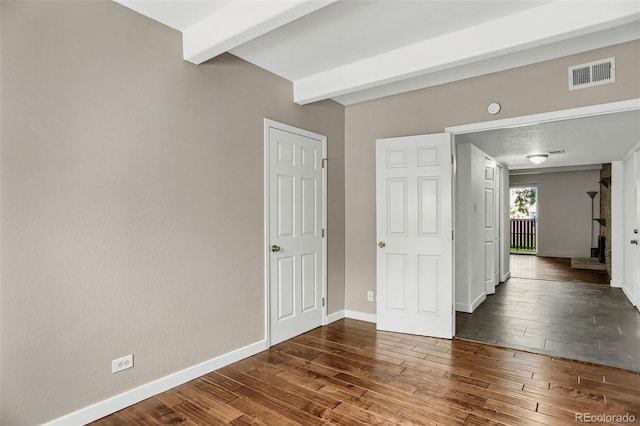 9995 E Harvard Ave Unit 290, Denver, CO 80231 - unfurnished room featuring dark wood finished floors, beamed ceiling, and baseboards