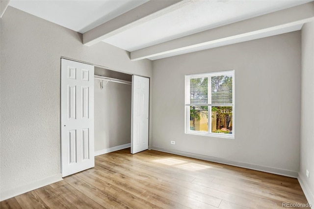9995 E Harvard Ave Unit 290, Denver, CO 80231 - unfurnished bedroom with beamed ceiling, light wood-type flooring, a closet, and baseboards