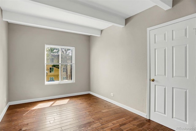 9995 E Harvard Ave Unit 290, Denver, CO 80231 - empty room with beamed ceiling, wood finished floors, and baseboards