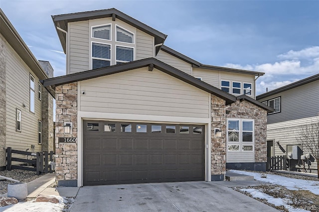 traditional-style home with a garage, stone siding, and concrete driveway