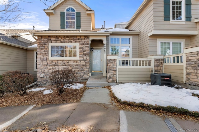 snow covered property entrance featuring central AC