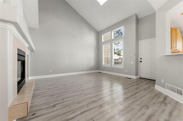 unfurnished living room featuring light wood-type flooring and high vaulted ceiling