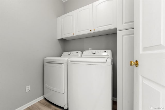 clothes washing area featuring light hardwood / wood-style flooring, cabinets, and independent washer and dryer