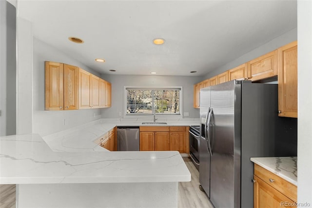 kitchen featuring kitchen peninsula, stainless steel appliances, sink, light brown cabinets, and light hardwood / wood-style floors