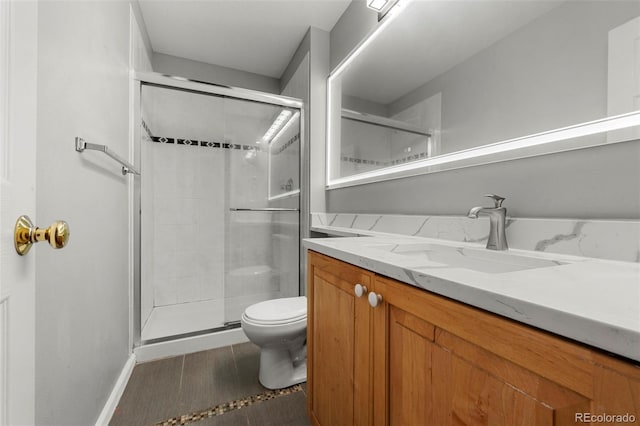 bathroom featuring vanity, toilet, and a shower with door