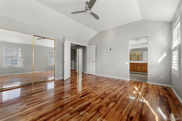 interior space with hardwood / wood-style floors, a closet, multiple windows, and lofted ceiling