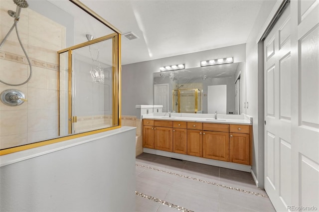 bathroom with tile patterned flooring, vanity, walk in shower, and a chandelier