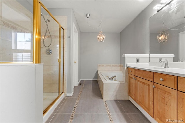 bathroom featuring tile patterned floors, vanity, shower with separate bathtub, and an inviting chandelier