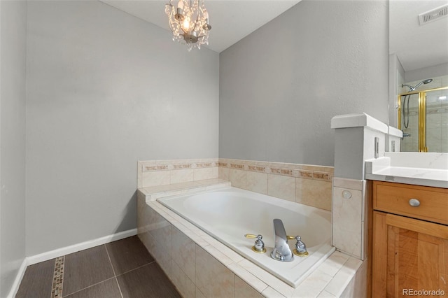 bathroom featuring tile patterned floors, vanity, plus walk in shower, and a notable chandelier