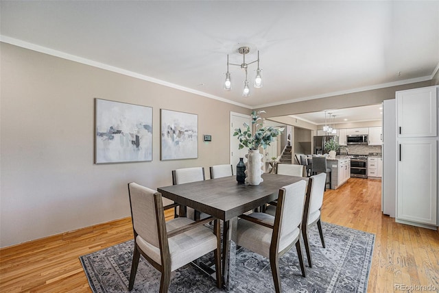 8712 W 64th Way, Arvada, CO 80004 - dining room with ornamental molding, light wood-style floors, and a chandelier