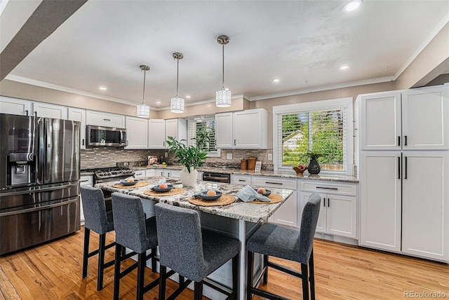 8712 W 64th Way, Arvada, CO 80004 - kitchen with stainless steel appliances, a kitchen breakfast bar, crown molding, tasteful backsplash, and light wood finished floors