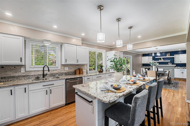 8712 W 64th Way, Arvada, CO 80004 - kitchen featuring stainless steel dishwasher, a sink, tasteful backsplash, a breakfast bar area, and crown molding