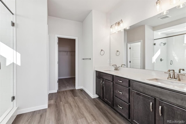 bathroom featuring vanity, wood-type flooring, and walk in shower