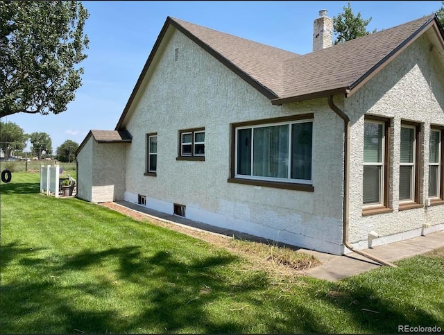 view of side of home with a lawn