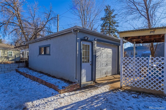 snow covered structure with a garage