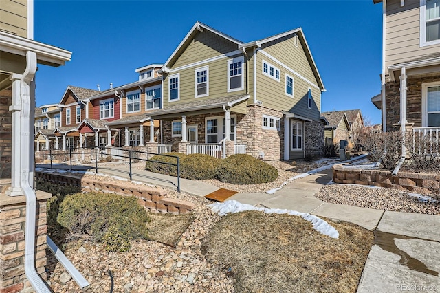 view of front of house with stone siding, a residential view, and fence