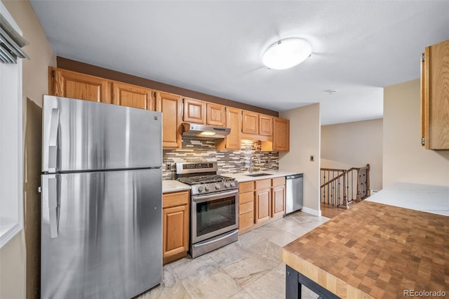 8051 S Kendall Blvd, Littleton, CO 80128 - kitchen with stainless steel appliances, under cabinet range hood, light countertops, tasteful backsplash, and light marble finish flooring